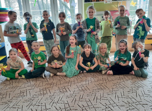 Zdjęcie grupowe - dzieci ubrane na zielono pozują z wykonanymi Marzannami