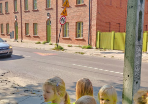 dzieci obserwują znaki drogowe