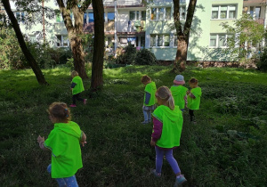 Dzieci zbierają śmieci podczas spaceru alejkami osiedla