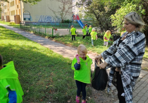 Dziewczynka wrzuca śmieci do worka