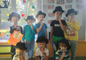 Chłopcy w kapeluszach i przyczepianych wąsach