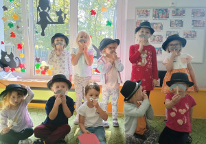 Dziewczynki w kapeluszach i przyczepianych wąsach