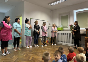 Pani dyrektor wręcza kwiaty pracownikom obsługi