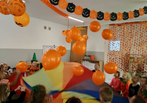 Dzieci podrzucają dyniowe balony