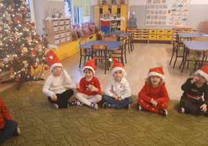 Dzieci w kole w mikołajkowych czapkach