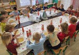 Dzieci jedzą obiad przy ustrojonym stole
