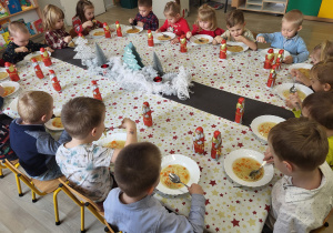 Dzieci jedzą obiad przy ustrojonym stole