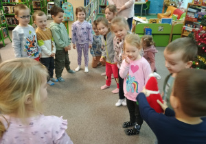Dzieci podają maskotkę Mikołaja w kole przy muzyce