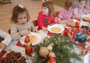 Dzieci spożywają świąteczny obiad przy dźwiękach kolęd