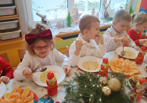 Dzieci spożywają świąteczny obiad przy dźwiękach kolęd