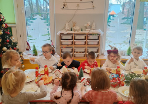 Dzieci spożywają świąteczny obiad przy dźwiękach kolęd