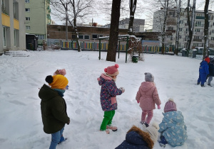 Dzieci lepią kulki ze śniegu