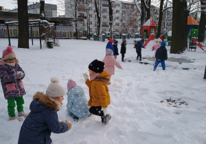 Dzieci lepią kulki ze śniegu
