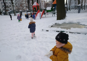 Dziewczynka lepi kulki ze śniegu