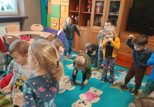 Dzieci dmuchają na płatki śniegu z piórek