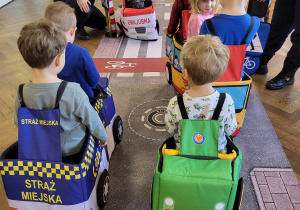 Dzieci w strojach samochodów chodzą po ulicznej macie