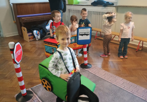 Dzieci przebrane za auta naśladują ruch na jezdni