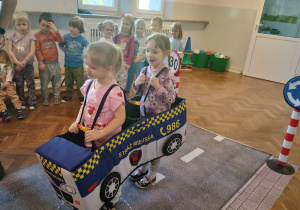 Dzieci przebrane za auta naśladują ruch na jezdni