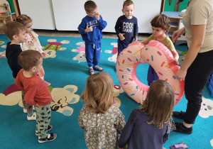 Dzieci w kole bawią się dmuchanym pączkiem