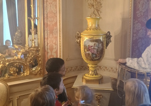 Dzieci słuchają ciekawostek o odnalezionym przedmiocie