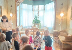 Dzieci szukają przedmiotów z plakietek w salonie