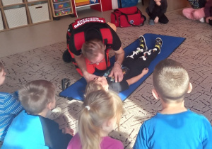 Ratownik pokazuje jak sprawdzić przytomność