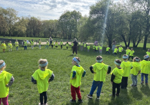 Dzieci stoją w kole na trawie