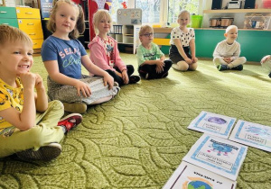 Dzieci siedzą na dywanie