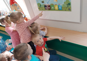 Dzieci pokazują do jakiego kosza należy wrzucać poszczególne odpady