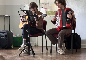 Muzycy grający na gitarze i akordeonie