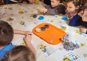 Dzieci z grupy III wkładają ozdoby do foremek do mydełek