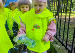 Dziewczynka trzyma w ręku plastikową butelkę