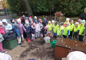 Dzieci patrzą na posadzone drzewko