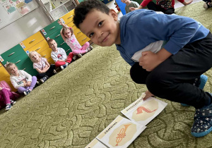 Chłopiec kładzie obrazek na dywanie