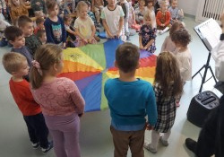 Dzieci uczestniczą w zabawie z chustą animacyjną