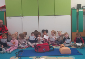 Dzieci pozują do zdjęcia z ratownikiem