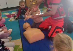 Dziewczynka wykonuje masaż serca na manekinie