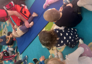 Ratownik układa dziewczynkę w pozycji bezpiecznej