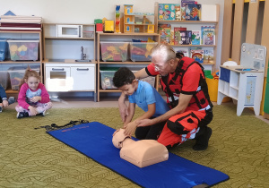 Chłopiec sprawdza przytomność na fantomie