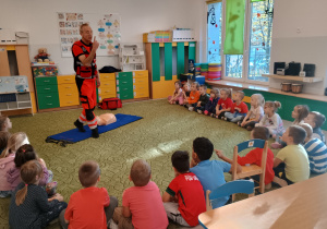 Dzieci pokazują usta i oczy zapamiętując numer alarmowy