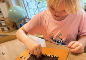 Dziewczynka wykonuje pracę plastyczną