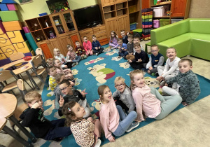 Dzieci siedzą na dywanie