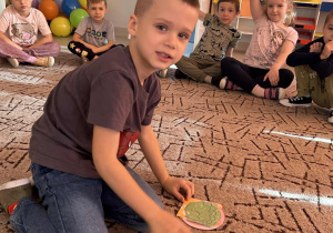 Chłopiec według instrukcji nauczyciela dobiera składniki kanapki