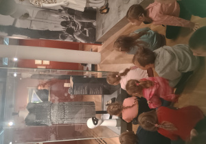 Dzieci podziwiają dawne nakrycia głowy