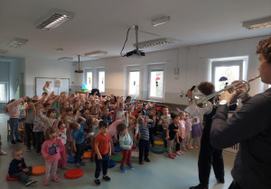 Dzieci śpiewają przy akompaniamencie trąbki