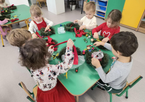 Dzieci dekorują wianki bożonarodzeniowe