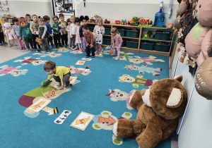Dzieci pokonują ścieżkę ruchową z misiowymi ilustracjami