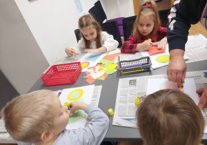 Dzieci kleją kawałki kolorowego papieru