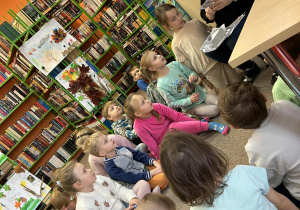 Dzieci słuchają historii na temat życia mieszkańców w danych latach