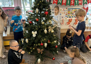 Dzieci dekorują choinkę